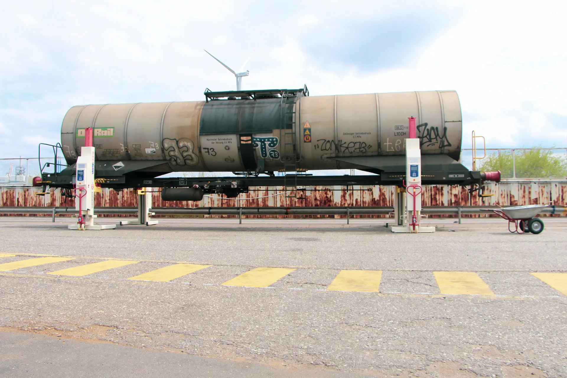 Grauer Kesselwagen mit Graffiti auf einem Gleis