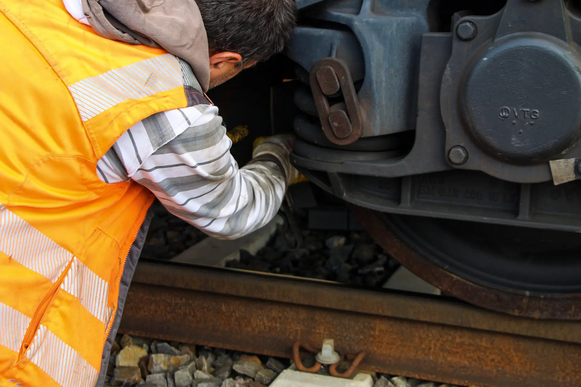 Arbeiter in orangefarbener Warnweste überprüft Bremssohlen