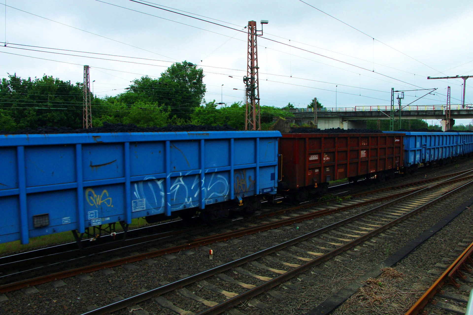Mehrere blaue und ein roter Güterwaggon